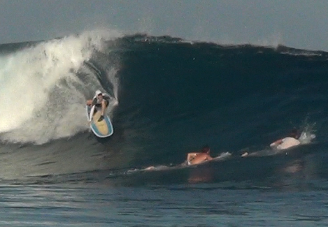 ASDS member Jordan Slutsky, MD, practicing Sun Safe Surfing in the tropical waves of Indonesia with his hooded UPF 50+ sun-protective rash guard.